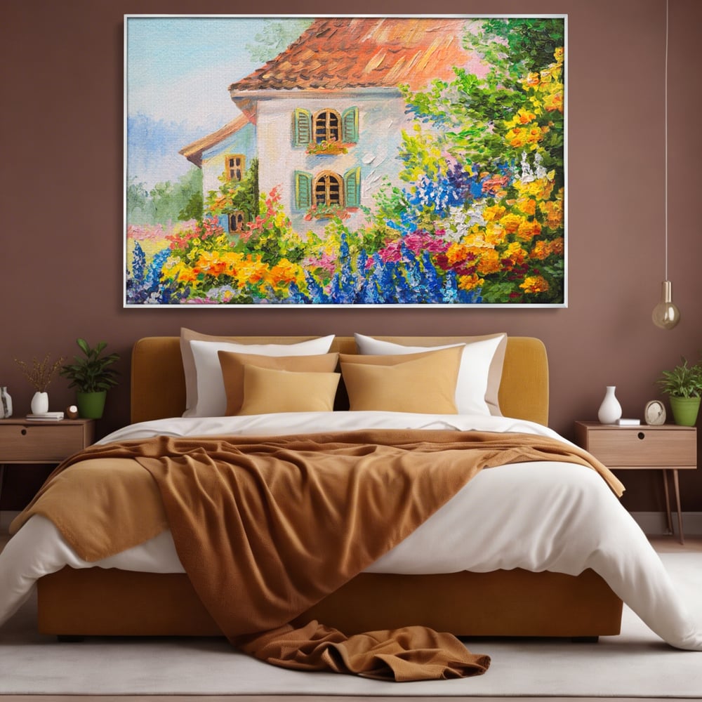 Tablou canvas cu pictura cu casa alba si flori, in rama de aluminiu argintiu, pe perete intr-un dormitor